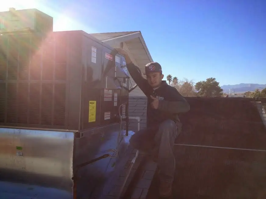 HVAC technician performing Air Duct Repair on a rooftop unit in Middletown